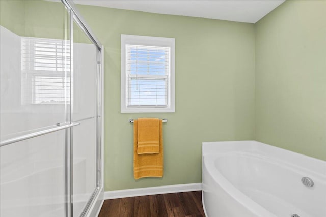 3055 Matthews Dr, Sumter, SC 29154 - bathroom with a bath, a stall shower, wood finished floors, and baseboards