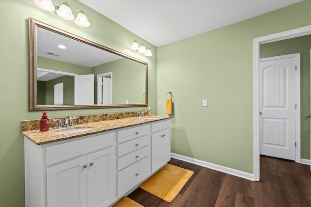 3055 Matthews Dr, Sumter, SC 29154 - full bath with wood finished floors, baseboards, and double vanity
