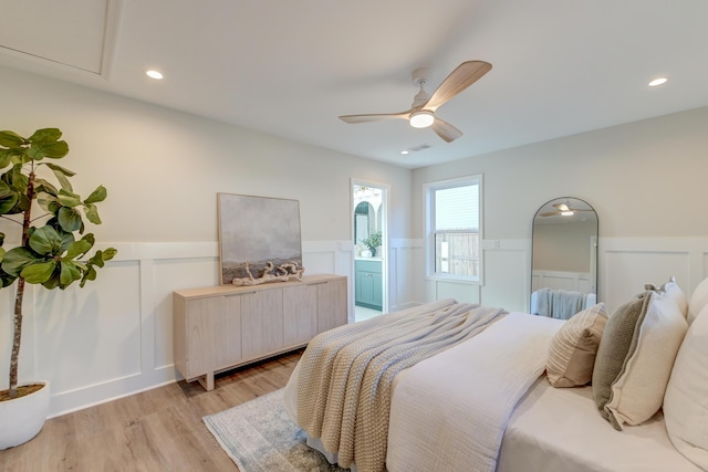 bedroom featuring ceiling fan, light hardwood / wood-style flooring, and ensuite bath