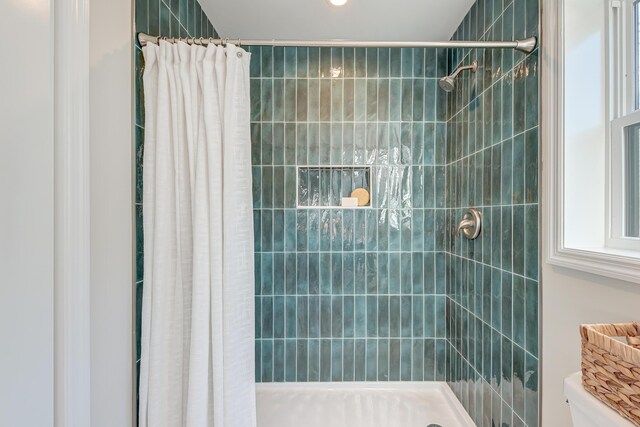 bathroom with toilet and a shower with shower curtain