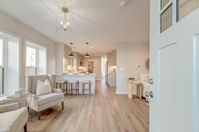 living area featuring light hardwood / wood-style flooring and a notable chandelier