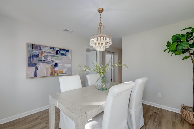 dining area featuring hardwood / wood-style flooring and a chandelier