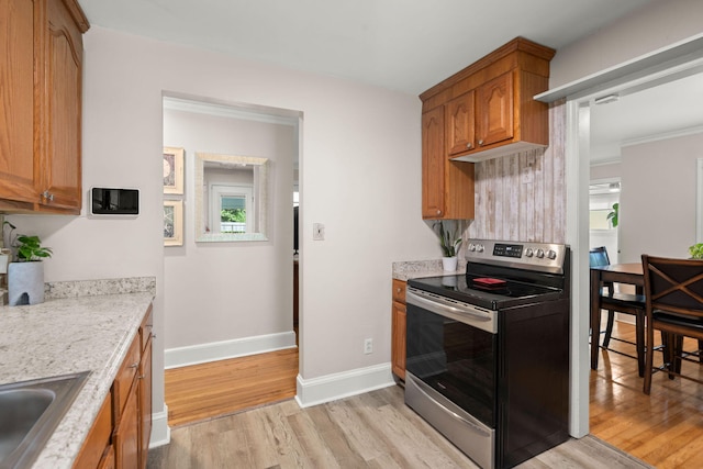672 W Oak Forest Dr, Charleston, SC 29407 - kitchen featuring electric range, light wood-style floors, baseboards, a sink, and brown cabinetry