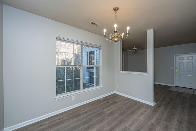 unfurnished dining area featuring ceiling fan with notable chandelier and dark hardwood / wood-style flooring