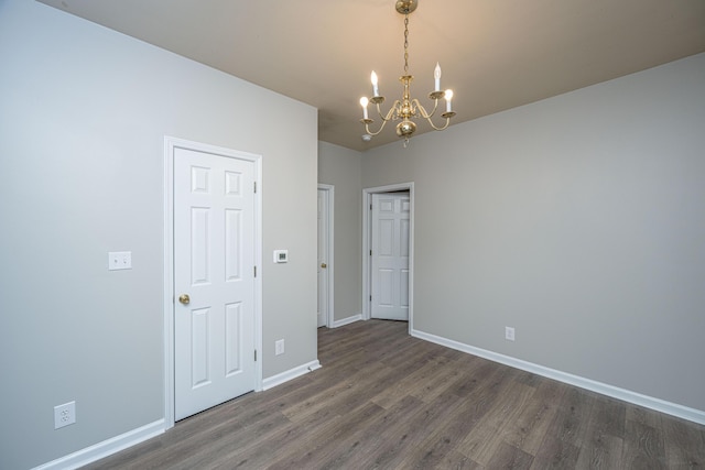 unfurnished room featuring dark hardwood / wood-style floors and a notable chandelier