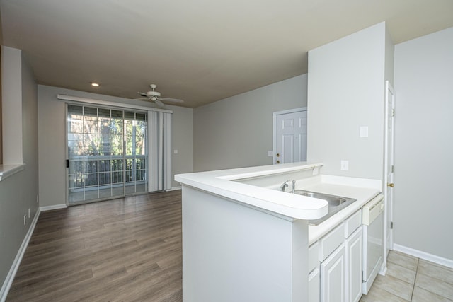 kitchen with ceiling fan, dishwasher, kitchen peninsula, sink, and white cabinetry