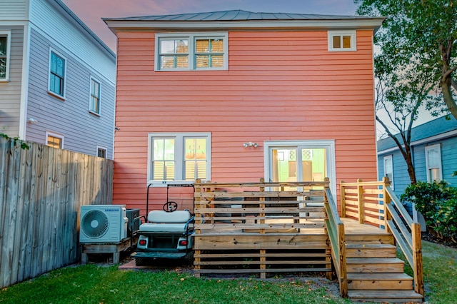 rear view of house with fence, ac unit, a yard, and a deck