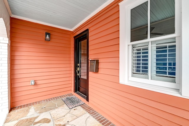 view of exterior entry featuring covered porch
