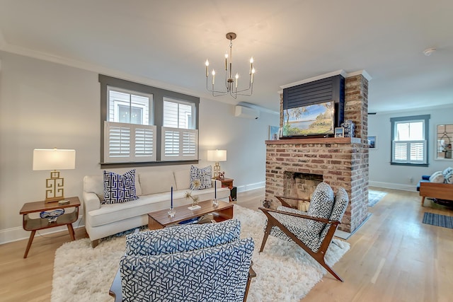 living room with a fireplace, wood finished floors, baseboards, an inviting chandelier, and ornamental molding