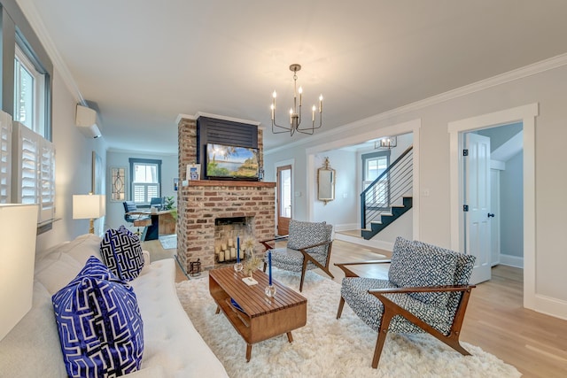 living area with ornamental molding, wood finished floors, a chandelier, and stairway