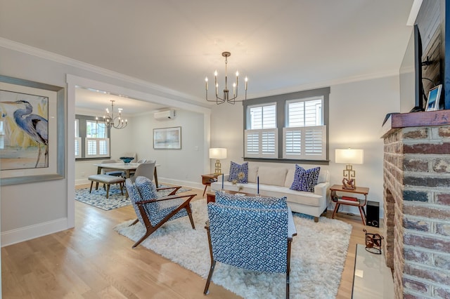 living area with a notable chandelier, ornamental molding, a wall mounted AC, and light wood finished floors