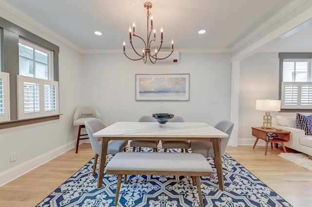 dining space with crown molding, baseboards, a chandelier, and light wood-style flooring