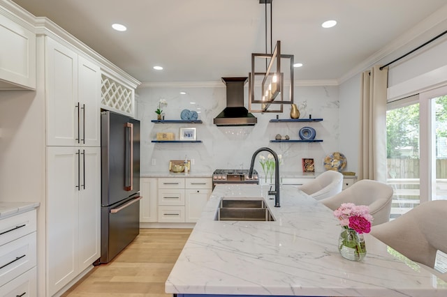 kitchen featuring open shelves, wall chimney range hood, tasteful backsplash, a sink, and stainless steel appliances