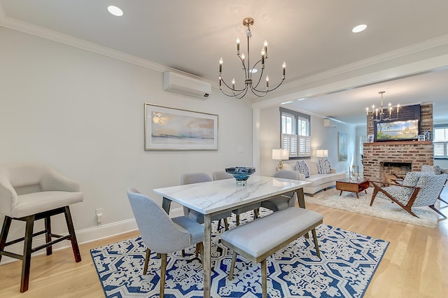 dining area featuring an AC wall unit, ornamental molding, a chandelier, and light wood-type flooring