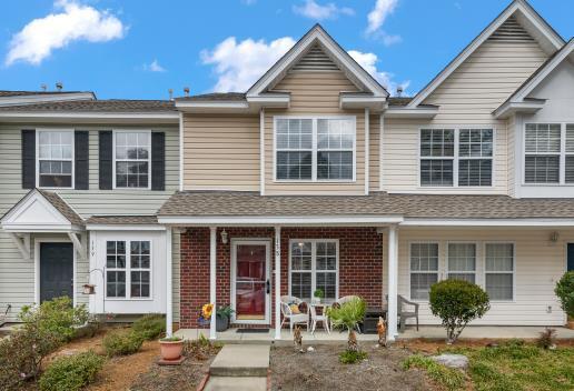 multi unit property featuring covered porch, brick siding, and a shingled roof