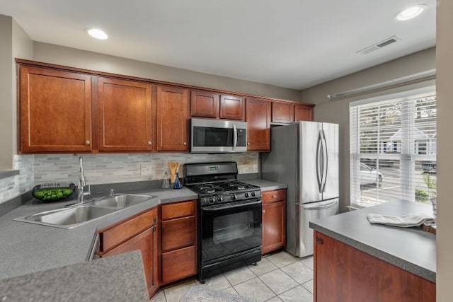 kitchen with stainless steel appliances, visible vents, a sink, and backsplash