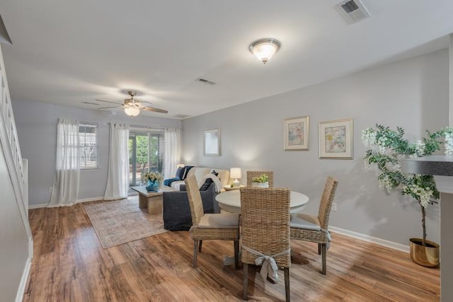 dining area with ceiling fan, wood finished floors, visible vents, and baseboards