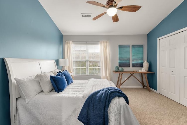 bedroom with baseboards, visible vents, ceiling fan, carpet, and a closet