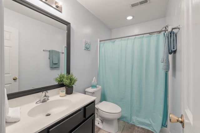 bathroom featuring visible vents, vanity, toilet, and wood finished floors