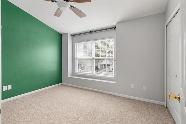 empty room with carpet, baseboards, and ceiling fan