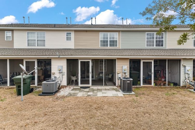 rear view of house with a patio, a yard, a sunroom, and central air condition unit