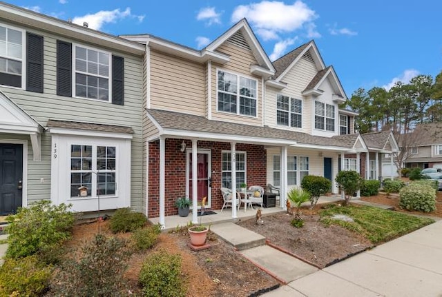 view of property with a porch and brick siding