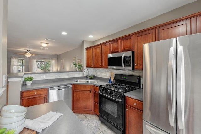 kitchen featuring light tile patterned floors, stainless steel appliances, decorative backsplash, a sink, and a peninsula