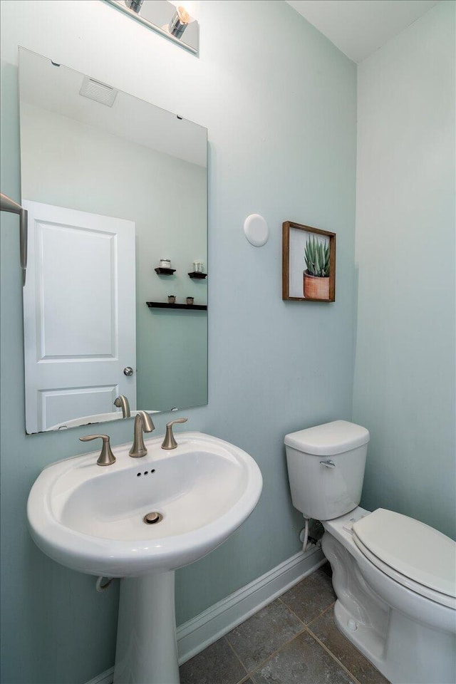 bathroom featuring toilet and baseboards