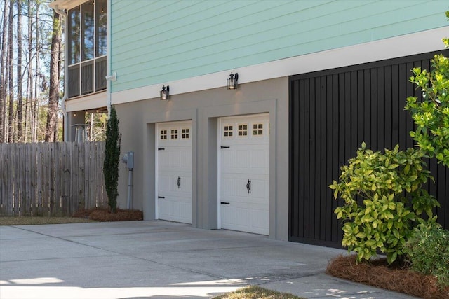 garage featuring fence and driveway