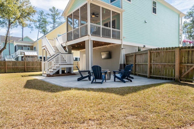 back of property featuring a lawn, a patio, a sunroom, stairway, and fence