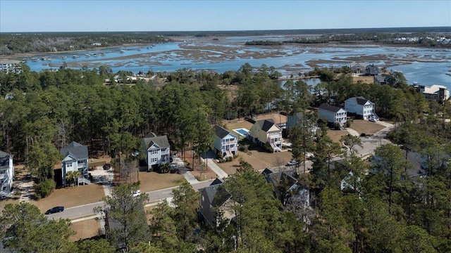 drone / aerial view with a water view, a residential view, and a view of trees