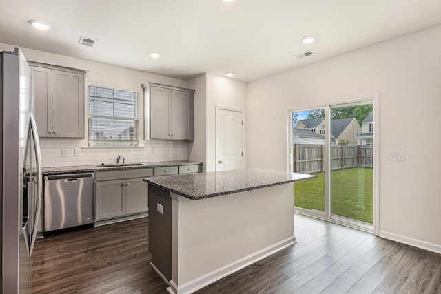 kitchen with gray cabinets, appliances with stainless steel finishes, a sink, dark wood-style floors, and recessed lighting
