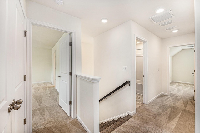hallway with an upstairs landing, light carpet, baseboards, and recessed lighting