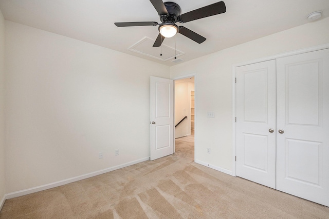unfurnished bedroom featuring light carpet, baseboards, a closet, and attic access