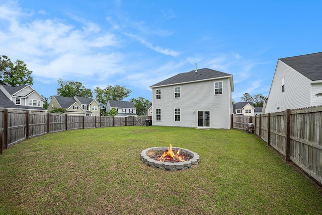 rear view of property featuring a fire pit and a residential view