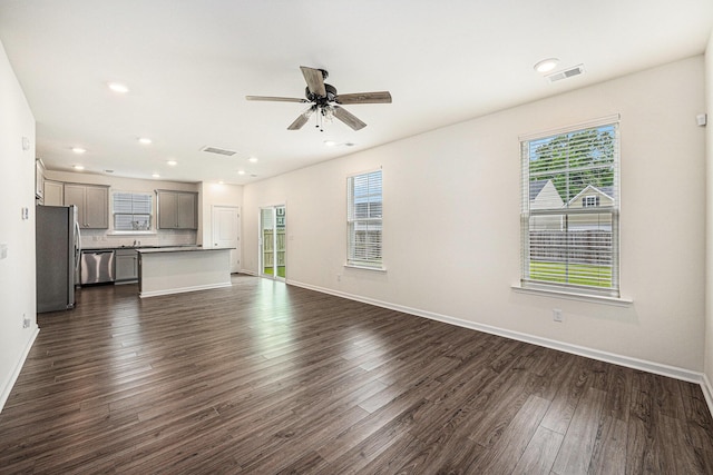 unfurnished living room featuring dark wood-type flooring, baseboards, a ceiling fan, and recessed lighting