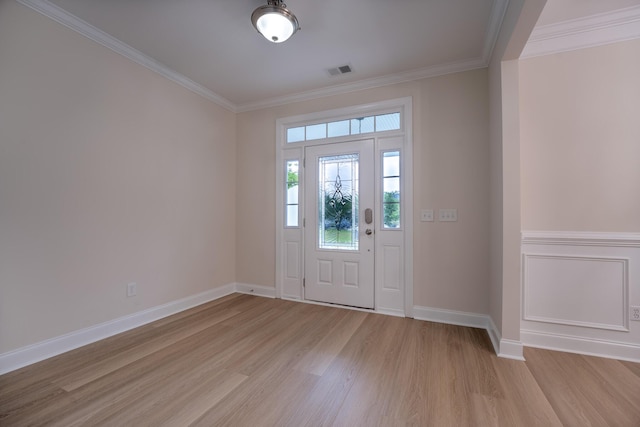 foyer with light wood-type flooring, ornamental molding, and baseboards