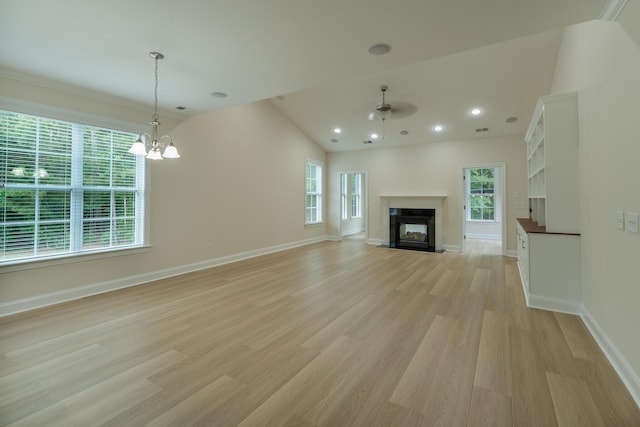 unfurnished living room with a ceiling fan, light wood-type flooring, a multi sided fireplace, a chandelier, and baseboards