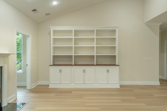 unfurnished living room with light wood-style flooring, vaulted ceiling, baseboards, a fireplace, and recessed lighting