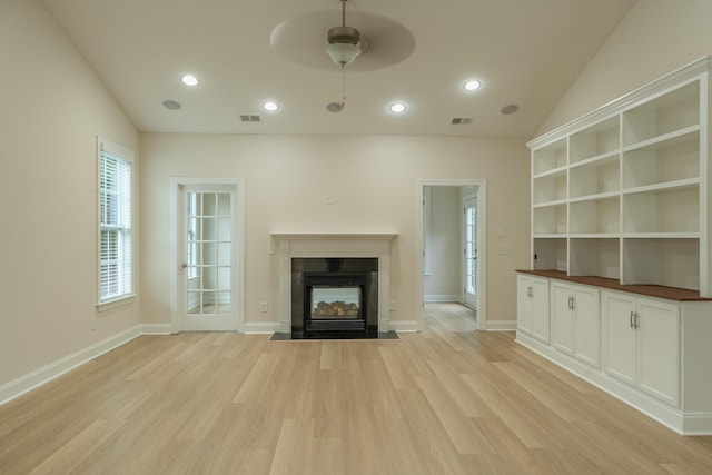 unfurnished living room with a multi sided fireplace, light wood finished floors, a ceiling fan, recessed lighting, and baseboards