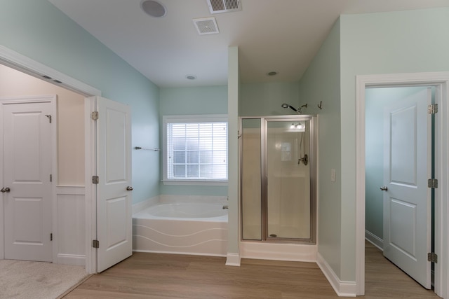 bathroom featuring wood finished floors, a shower stall, and a bath
