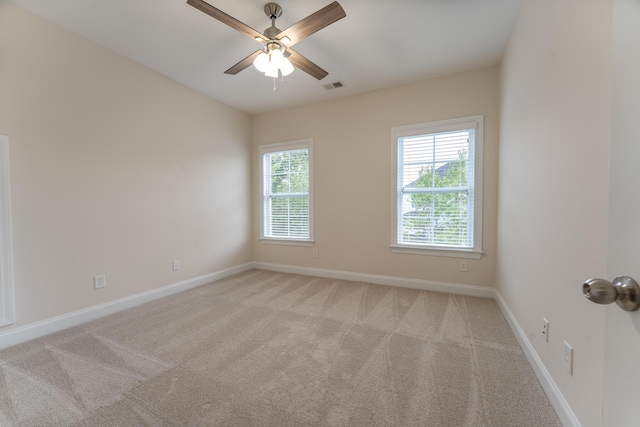 spare room with light carpet, baseboards, and ceiling fan