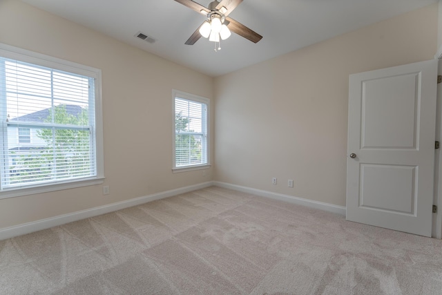 empty room with ceiling fan, baseboards, and light colored carpet