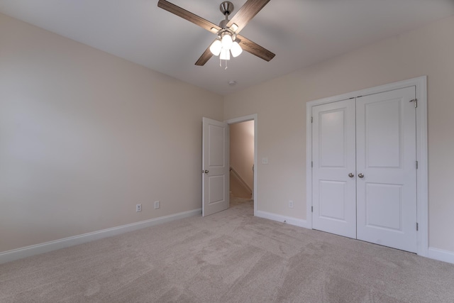 unfurnished bedroom with light carpet, baseboards, and a closet