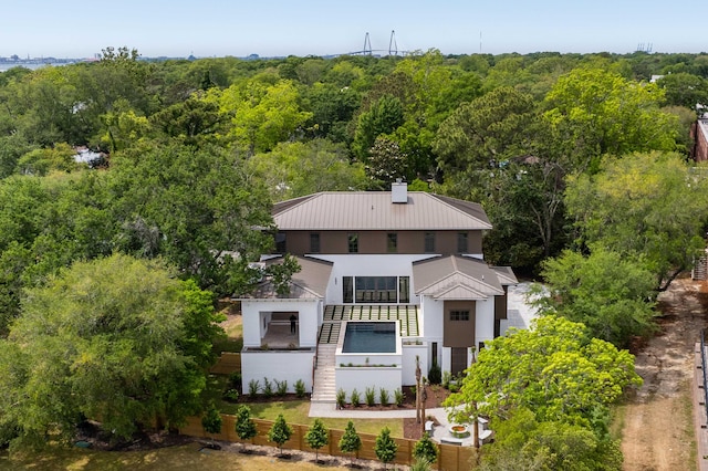 aerial view of property and surrounding area with a heavily wooded area