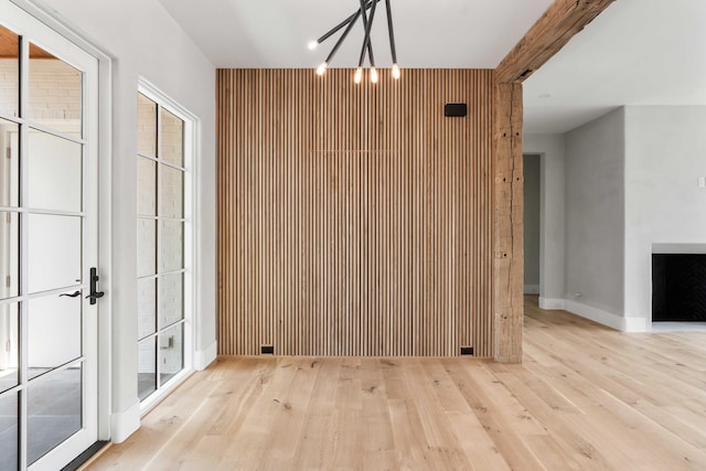 unfurnished dining area featuring a chandelier, wood finished floors, baseboards, and plenty of natural light