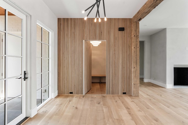 unfurnished dining area with wood finished floors, a chandelier, and baseboards