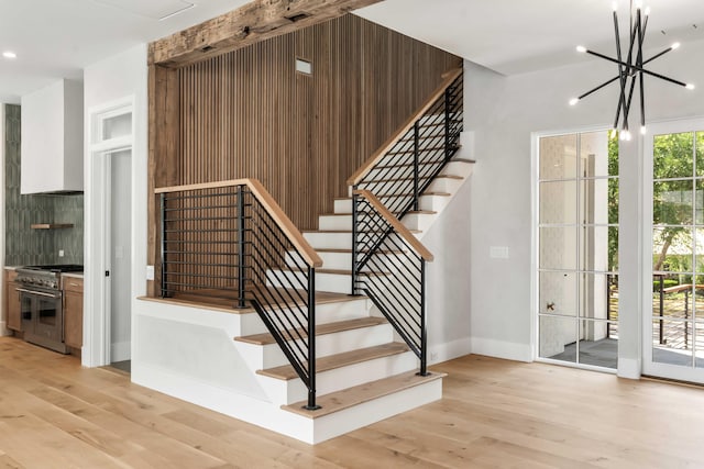 stairs with wood finished floors, baseboards, a chandelier, and recessed lighting