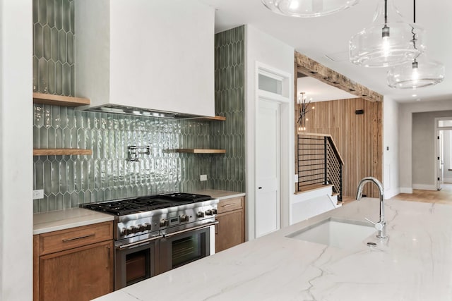 kitchen featuring double oven range, a sink, open shelves, and exhaust hood
