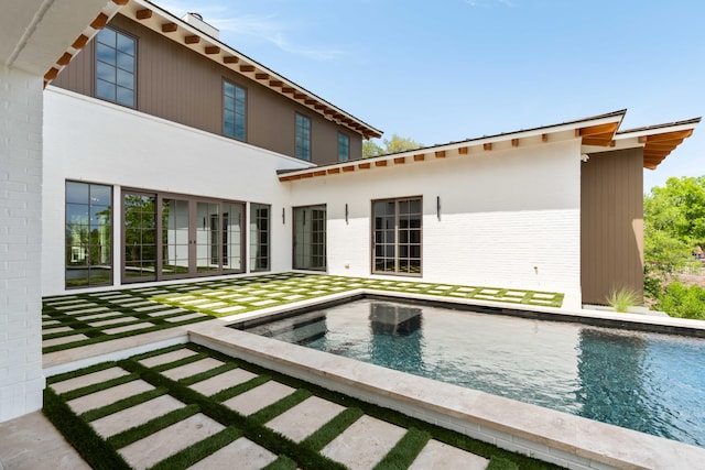 back of house with brick siding and an outdoor pool